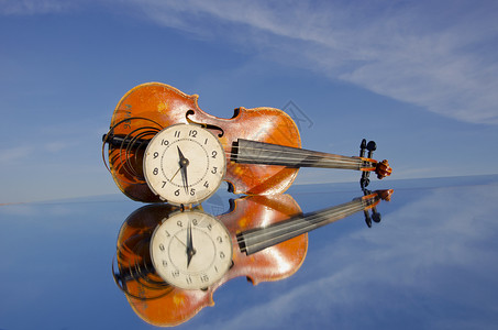 旧小提琴和时钟表背景图片