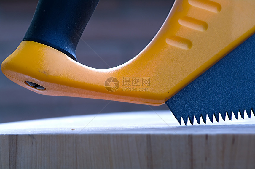 木锯木宏观建造手锯工具黄色木头金属刀刃工作图片