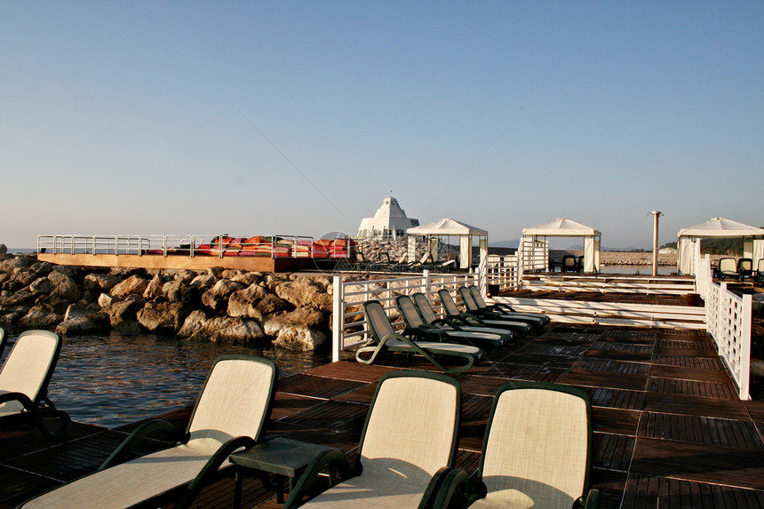 美丽的热带海滩天堂天空酒店异国太阳海浪休息室旅游椅子日光图片
