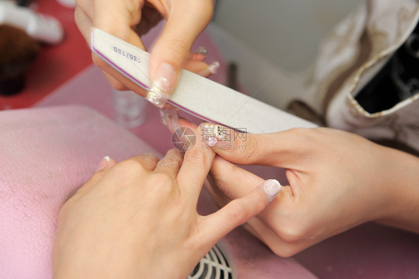 女性手上的修指甲过程中心治疗化妆品工作室桌子抛光身体绘画拇指美容师图片