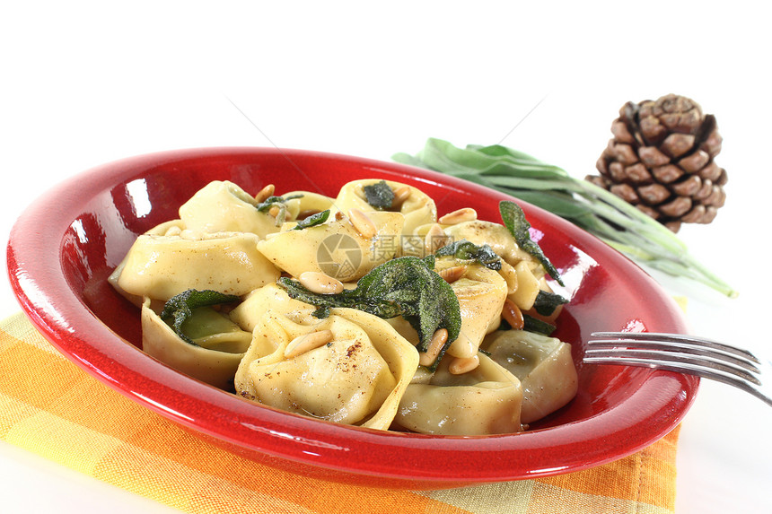 带圣子的托尔特利尼素食盘子黄油美食智者饺子食物松子乳制品图片