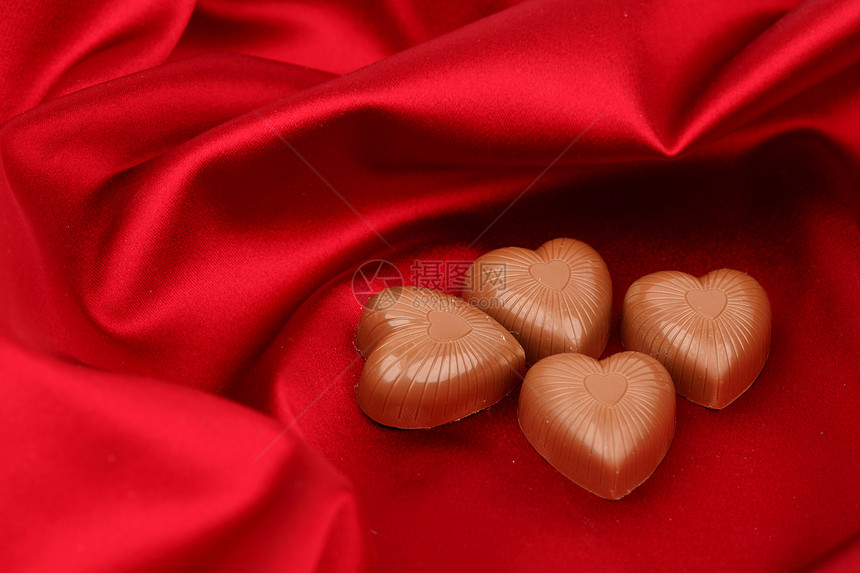红沙子上的糖果心礼物巧克力丝带盒子庆典织物展示生日标签金子图片