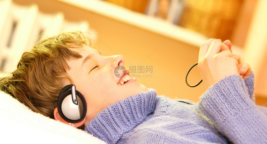 男孩听音乐家庭作业键盘房间学校青少年耳朵小伙子们学习耳机教育图片
