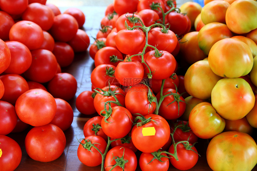 堆叠在市场不同种类的番茄类图片