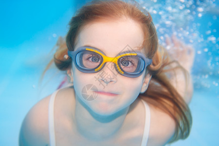带护目镜的水下 女童女孩有趣微笑风镜孩子游泳衣潜水员水池女性蓝色泳装幸福假期高清图片素材