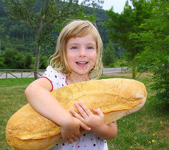 女童面包裤拥有大面包幽默的女童饥饿儿童蓝色快乐童年孩子手势小吃女性乐趣微笑金发背景