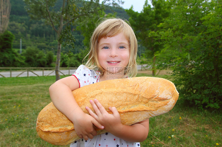 拥有大面包幽默的女童饥饿儿童午餐眼睛快乐手势女孩面包女性孩子树木微笑图片