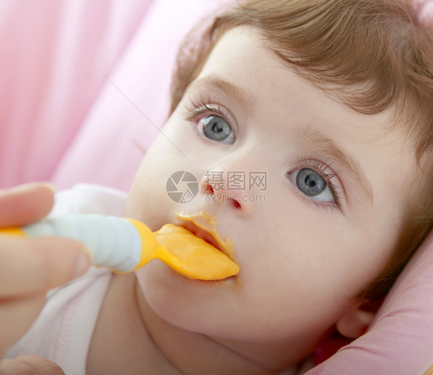 奶母喂养婴儿黄勺子女儿女孩家庭幸福宏观金发蓝色母亲童年橙子图片