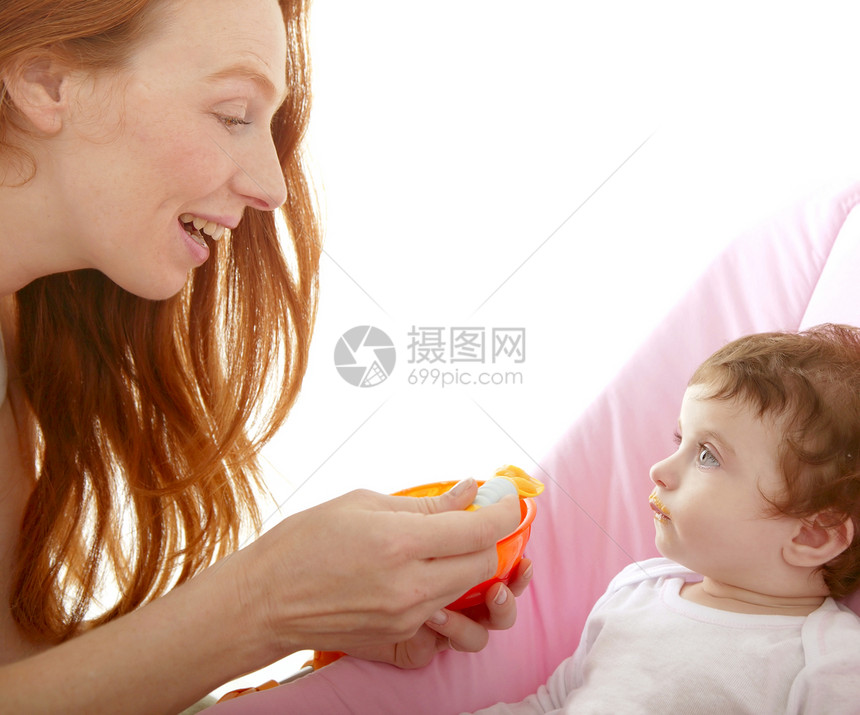 奶母喂养婴儿黄勺子宏观童年拥抱母亲女士幸福眼睛妈妈皮肤女孩图片