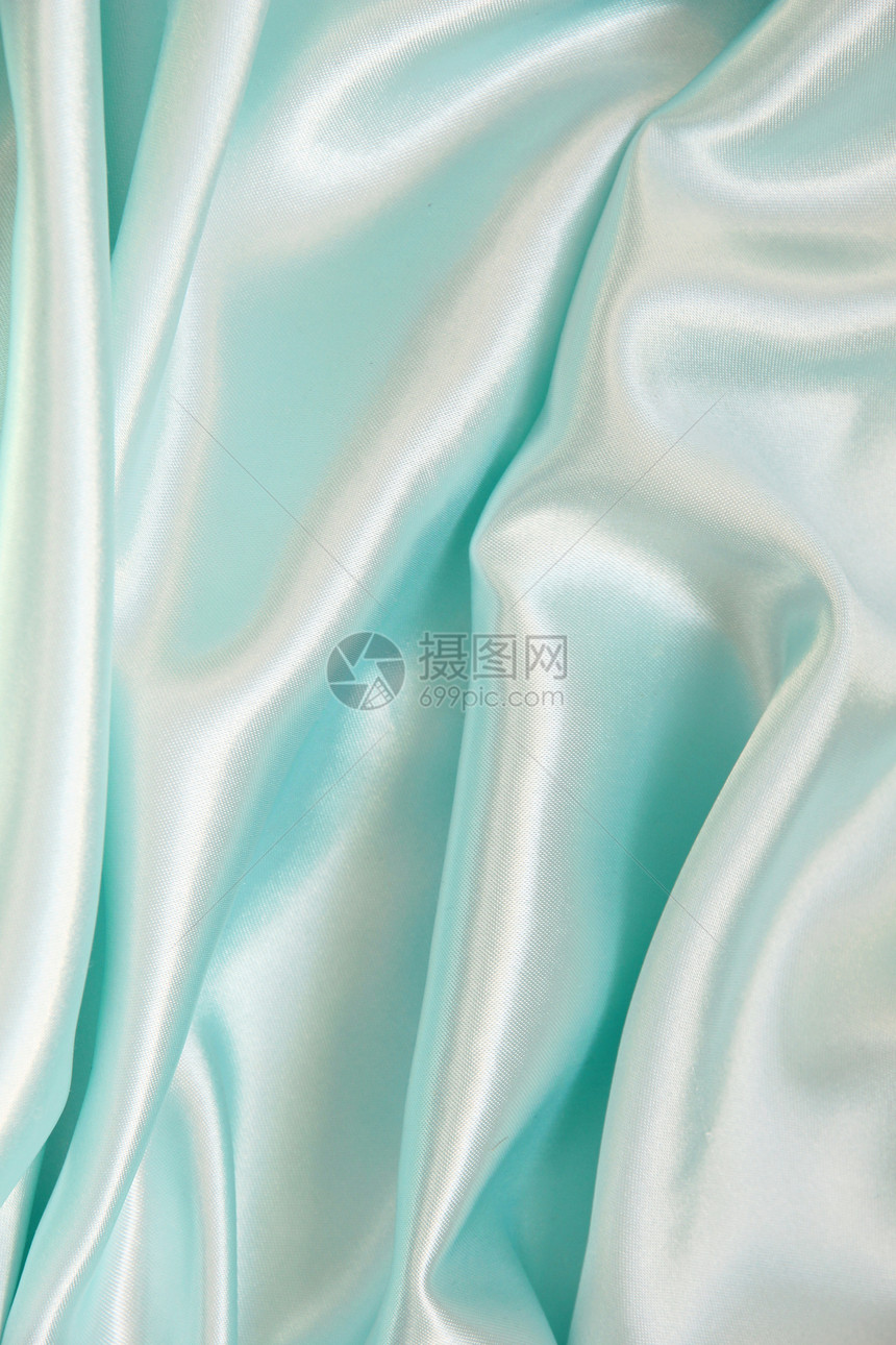 平滑优雅的蓝色丝绸作为背景曲线纺织品材料布料银色投标织物折痕海浪图片