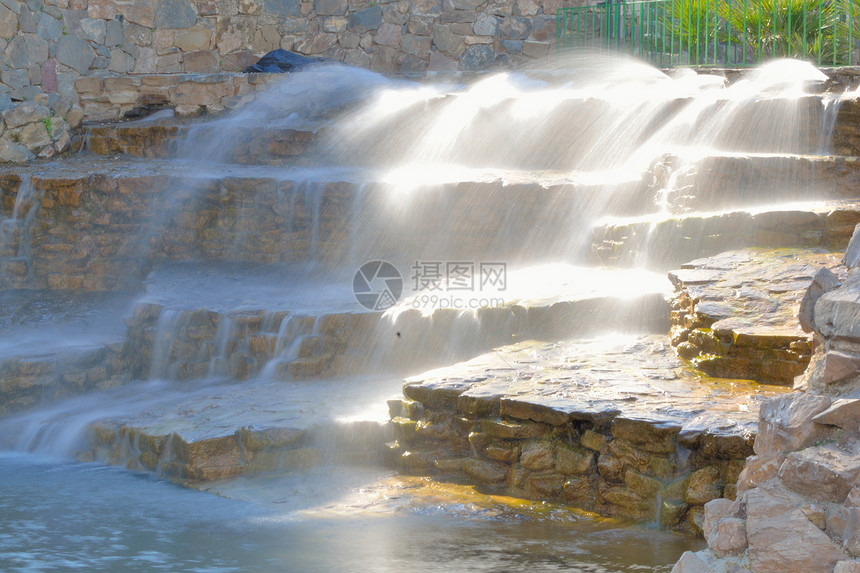 公园的瀑布岩石蓝色溪流环境棕色花园流动石头图片