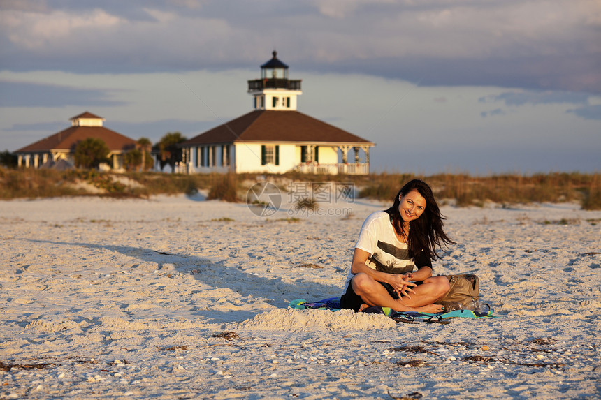 海滩上的女孩日落微笑女士旅行游客晒黑灯塔入口图片