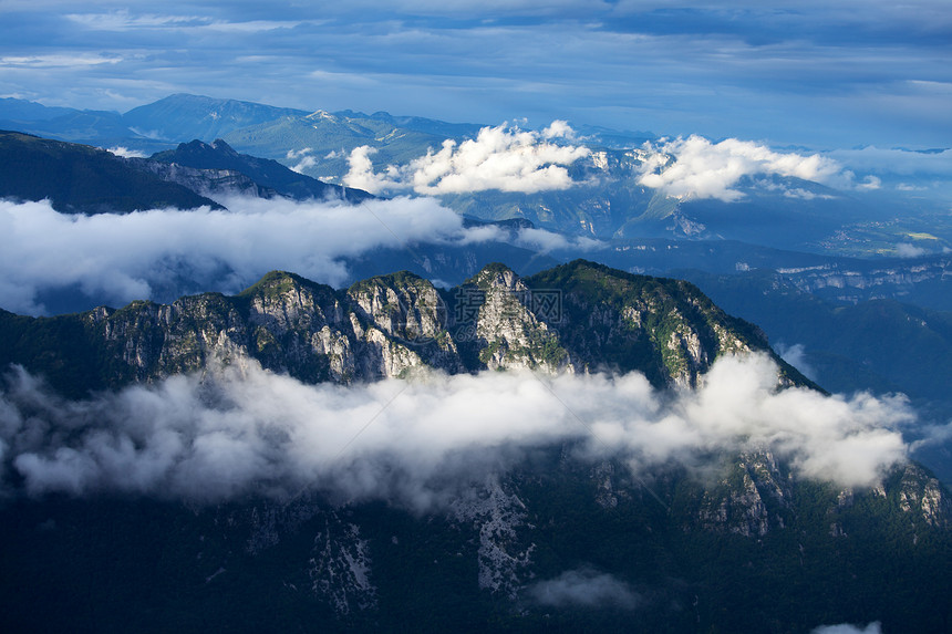 在意大利山高的云中乡村多云场景戏剧性蓝色天空阳光爬坡岩石顶峰图片