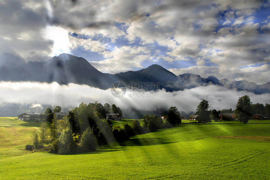 早晨在阿尔卑斯山树木天空国家草地高山阴霾耀斑山脉村庄山峰图片