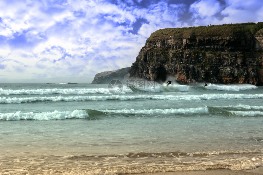 悬崖附近的冲浪者享受力量风暴海浪冲浪海滩天气海洋男人蓝色图片