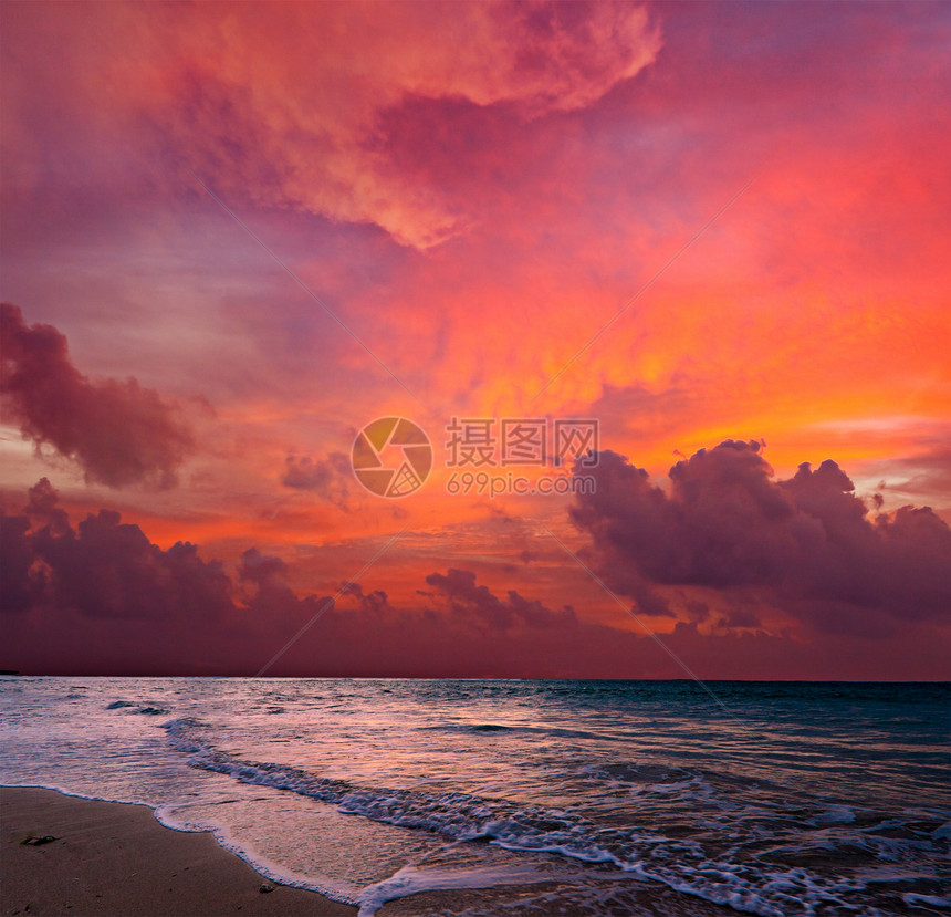 热带日出时的平静海洋和海滩海浪天空地平线太阳日落波浪图片