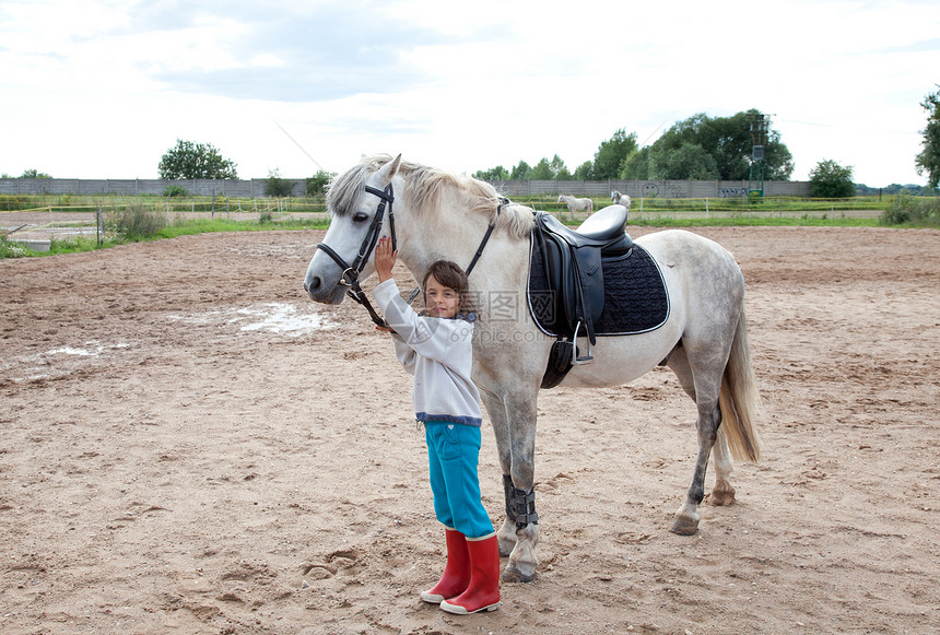 小女孩准备上骑马赛课了宠物生物马术休闲骑术女孩女性化乐趣农场灰色图片