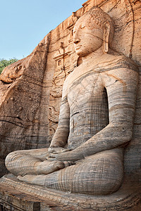 古老的佛像静坐着石头雕像岩石背景图片