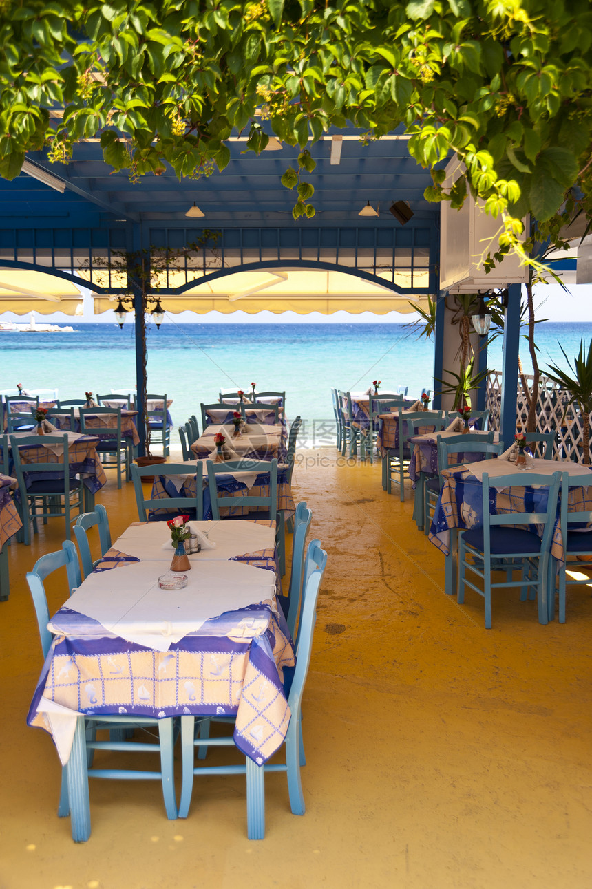 萨莫斯市Kokkari酒馆牧歌海滩波浪蓝色科卡桌子人行道椅子娱乐咖啡馆图片