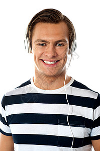 微笑的年轻人通过耳机收听音乐背景图片