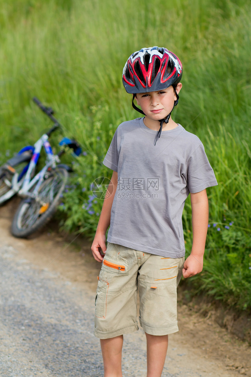 男孩戴头盔的骑自行车运动员肖像幸福绿色男生男性运动孩子学校衣服童年竞赛图片