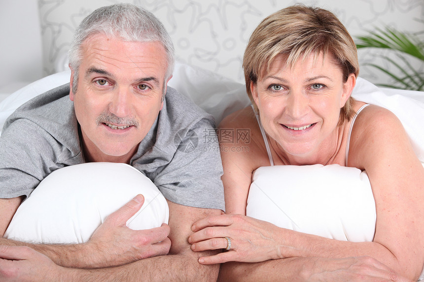 床上的成熟夫妇灰色白色卧室幸福丈夫女士女性男人男性说谎图片