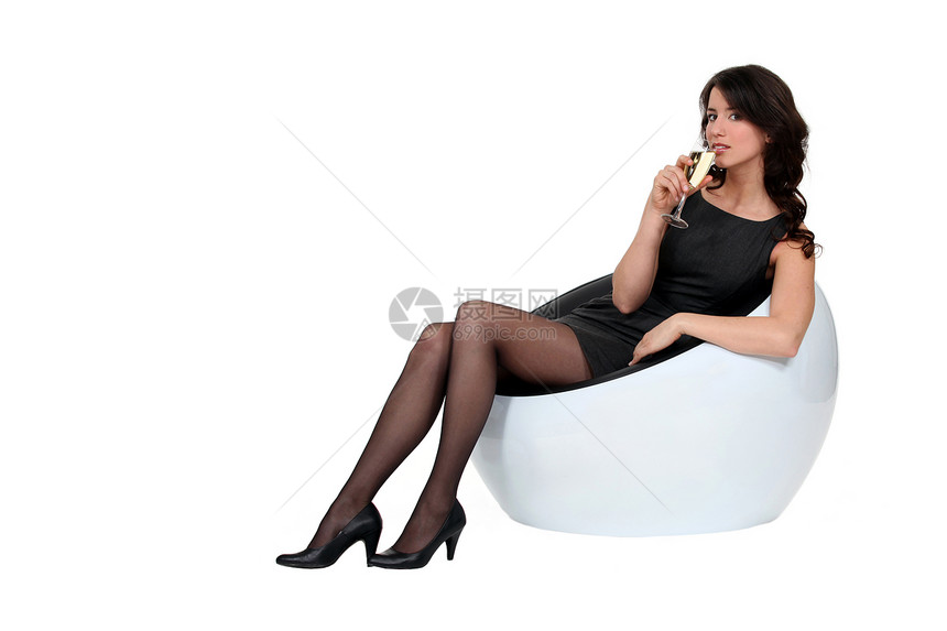 女人坐在沙发上 拿着香槟喝着图片