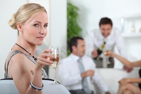 一位喝着葡萄酒的女人的肖像金发女郎客厅女士朋友们派对友谊乐趣邀请函裙子客人漂亮的高清图片素材