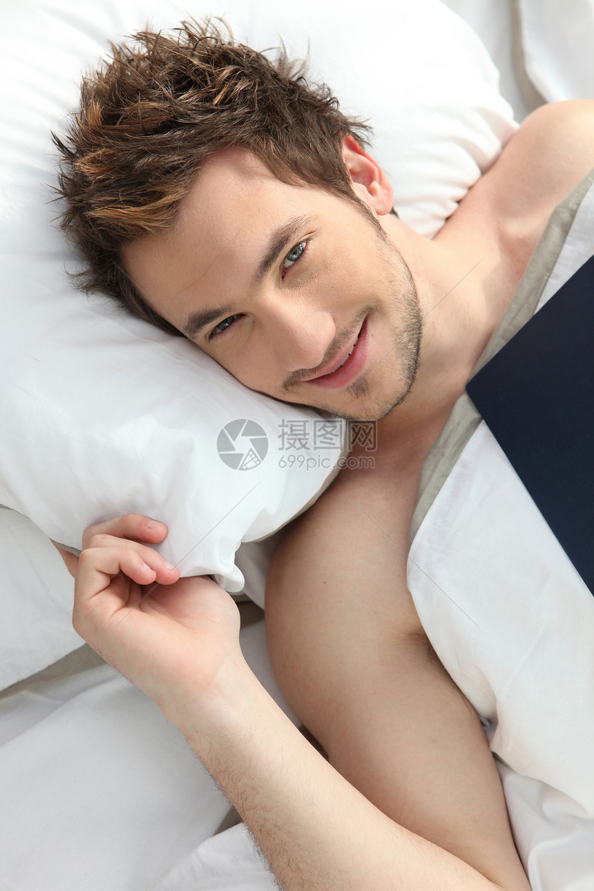 年轻人在床上微笑图片