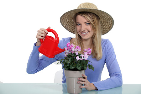 我粉色帽子青年妇女饮用饮用水植物背景