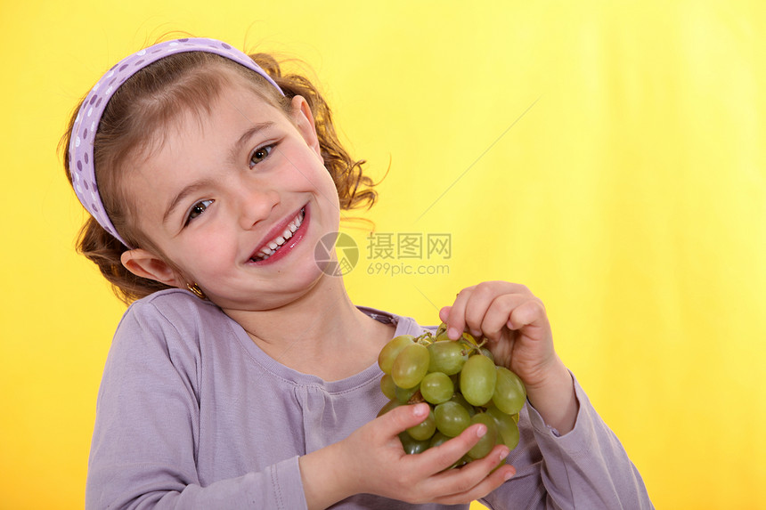 小女孩拿着一帮葡萄子图片