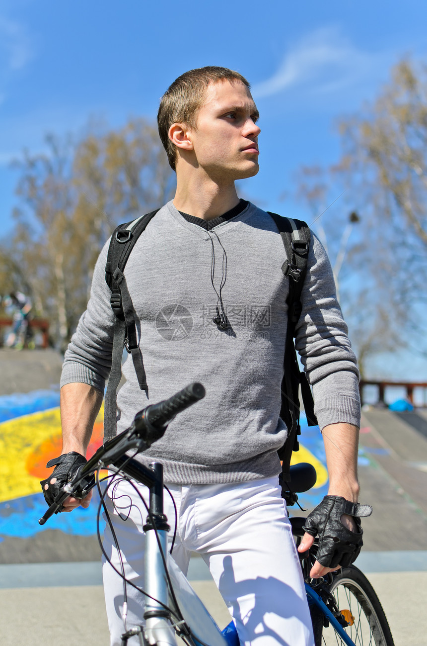 城市滑板场背景的BMX自行车骑手肖像街道骑士背包小轮车极限城市青少年男性闲暇娱乐图片