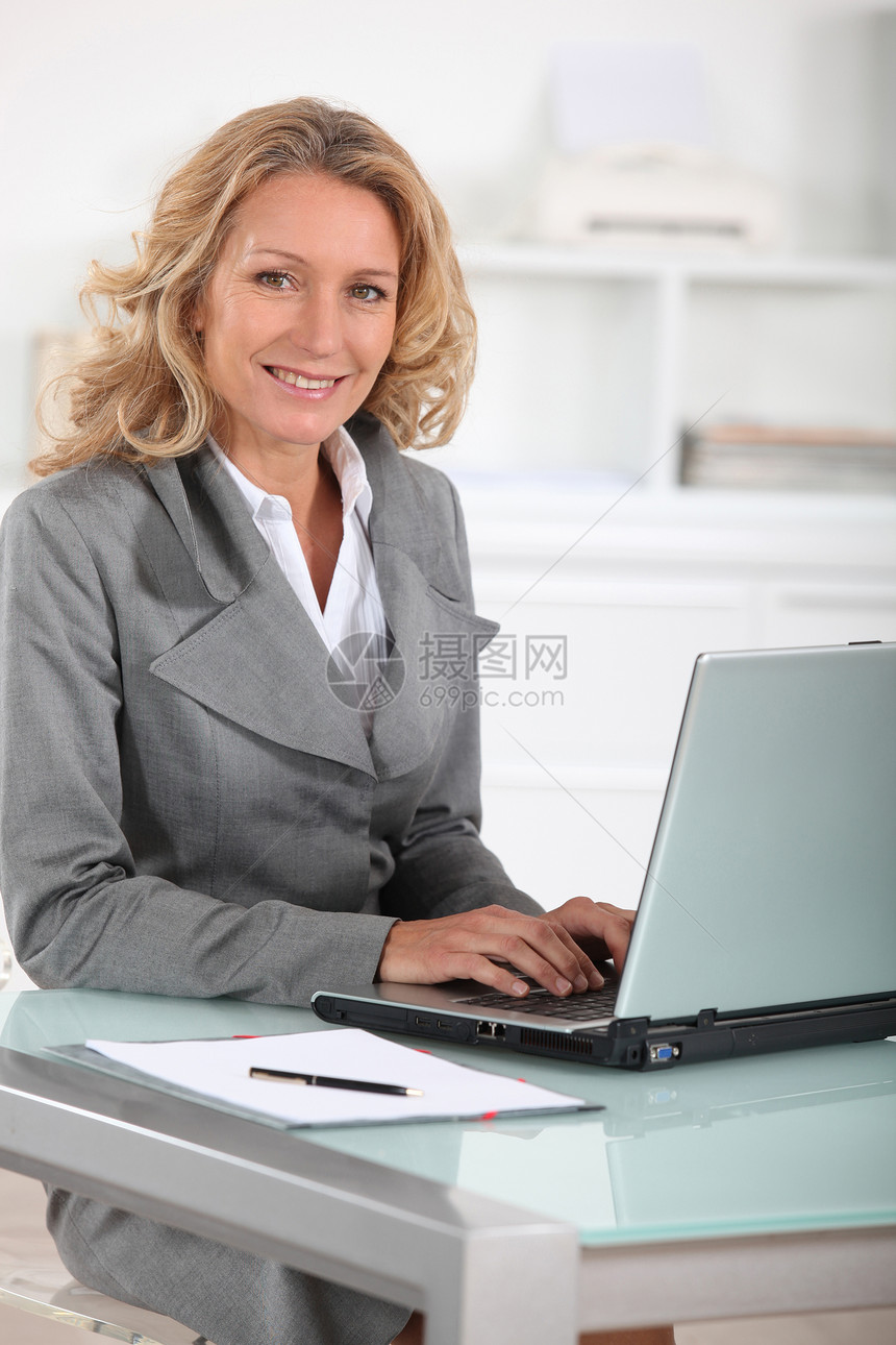 膝上型计算机的女性执行官中年人办公室成人套装职业沟通上网思维管理人员笔记本图片