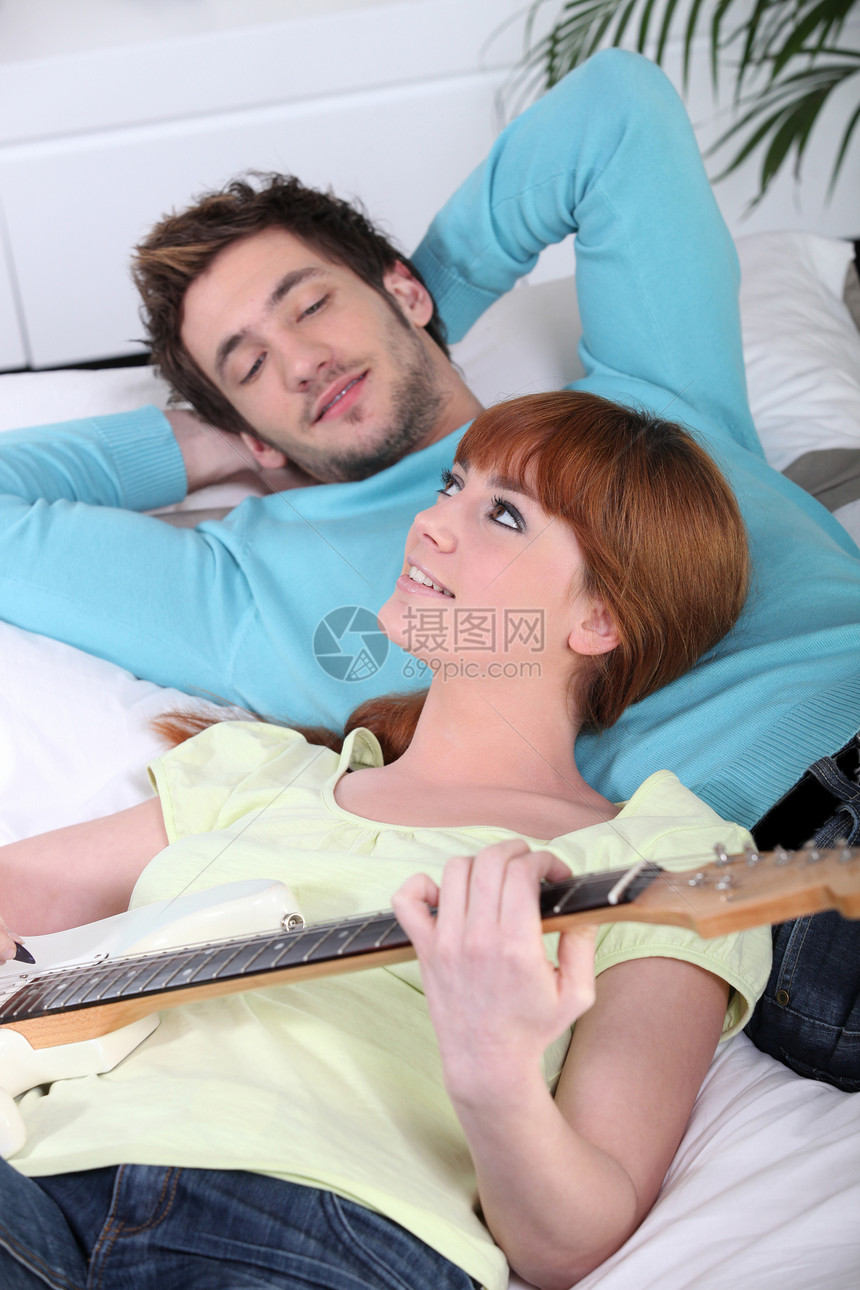 年轻女性和年轻男性在弹吉他时放松图片