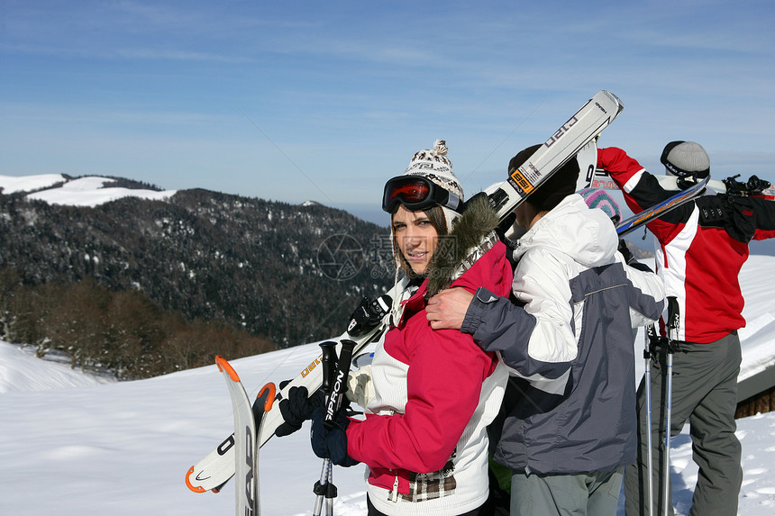 一群年轻的滑雪青年站在山顶上图片