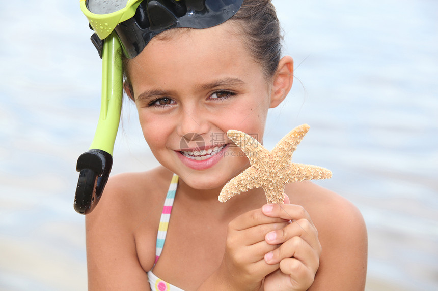 沙滩上的小小女孩 抓着明星鱼图片