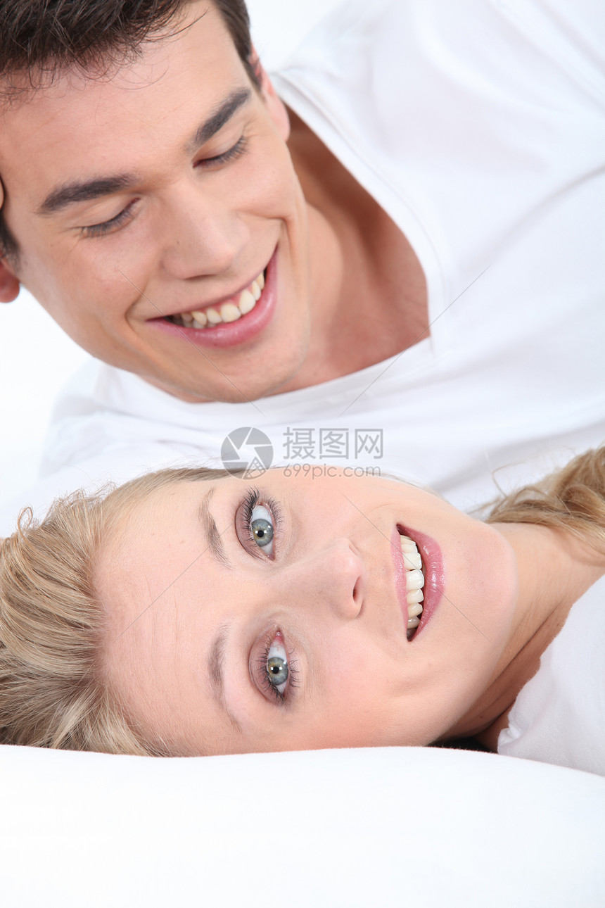 微笑的年轻夫妇躺下图片