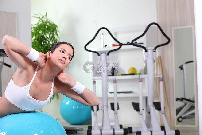 在健身房做腹部运动的年轻女青年图片