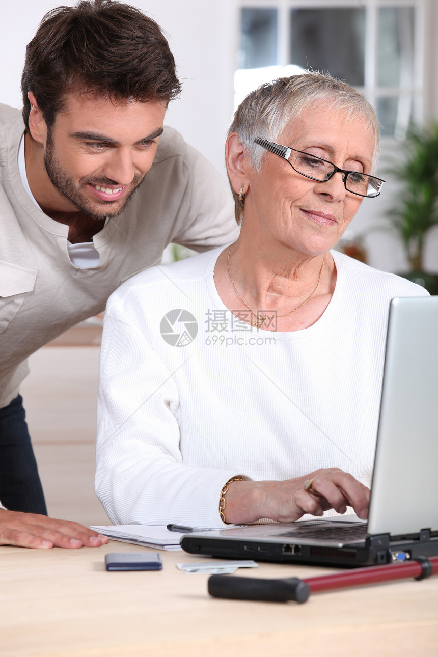 男人用电脑帮助老太太图片