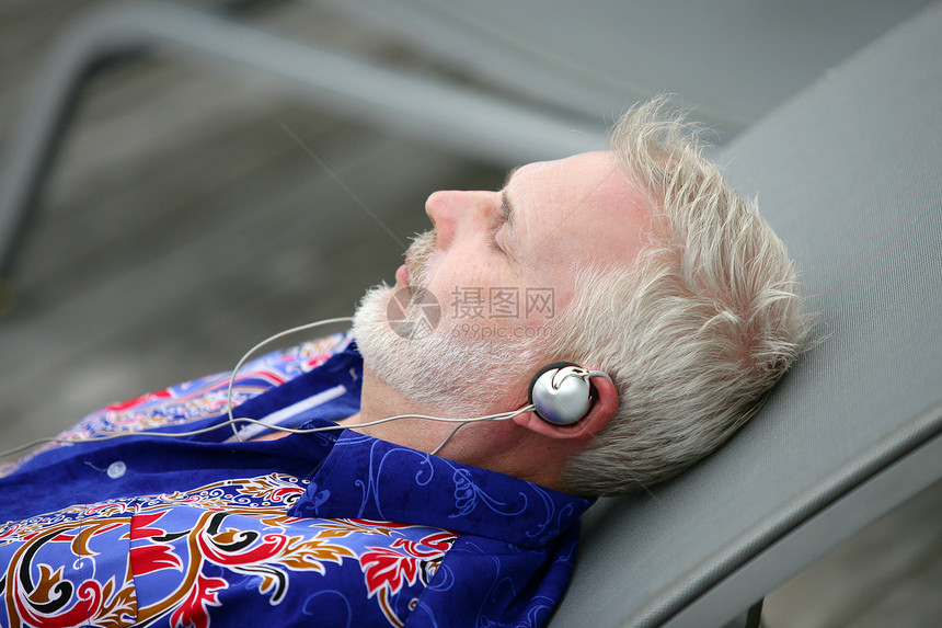 男人躺在甲板椅子上听音乐图片