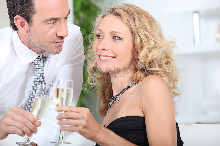来一杯香槟庆祝一对情侣衬衫丈夫金发夫妻微笑眼睛周年干杯妻子玻璃图片