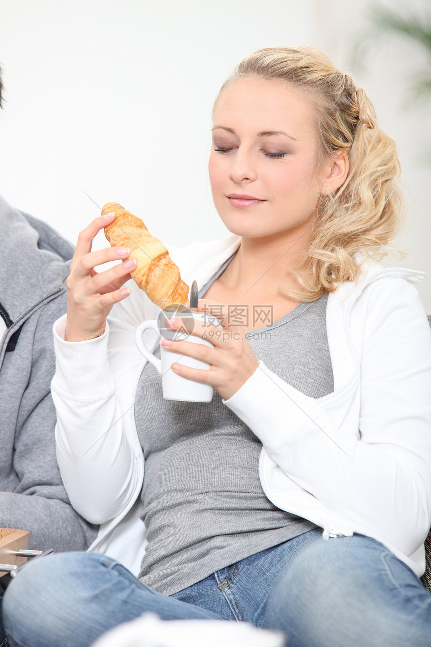 妇女享受咖啡和羊角面包图片