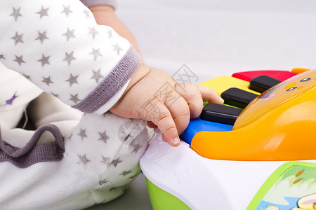 初生男婴玩玩具钢琴背景图片