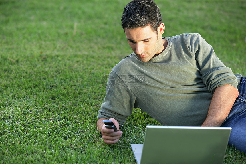 人用笔记本电脑在草地上图片