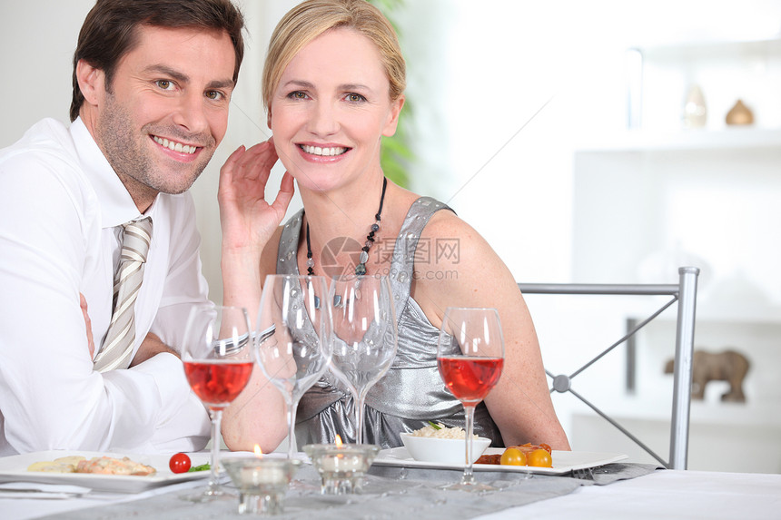 一个优雅的情侣在吃晚饭 对我们微笑图片