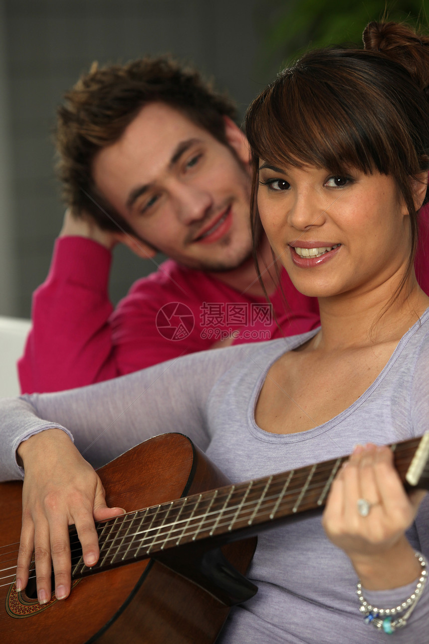 男人看女人弹吉他夫妻女士朋友压痛微笑吉他手沉思音乐长椅货架图片