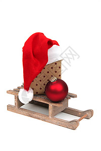 平底雪橇圣诞礼物在雪橇上惊喜礼物平底引擎盖木头绒球红色包装纸运动礼品背景