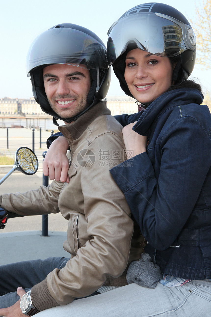骑摩托车的夫妇城市乘客骑术头盔城市化发动机运输面孔车手反思图片