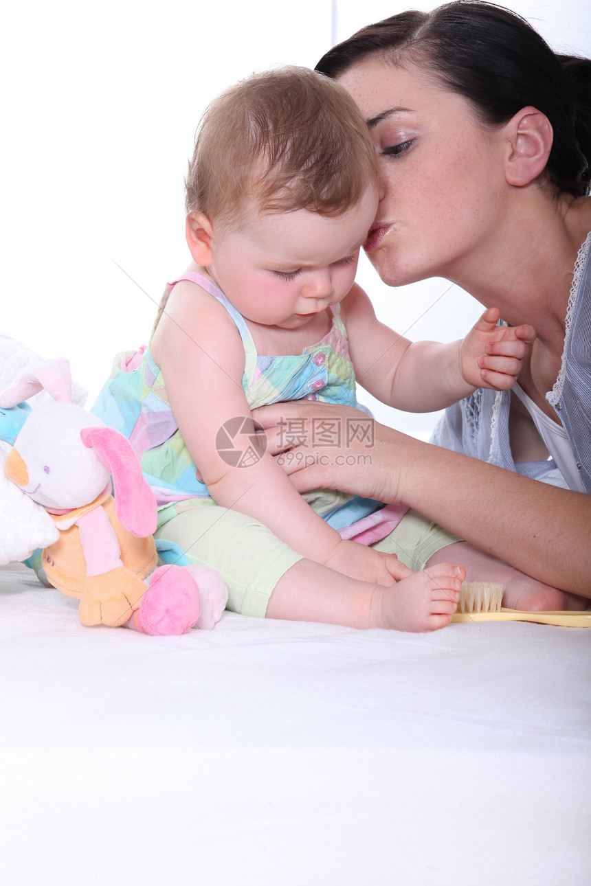 母亲与婴儿金发拥抱毛绒衬衫房子刷子玩具幸福家庭照顾图片