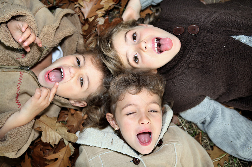 儿童躺在地上姐姐地面幸福微笑衣服童年树叶男生团体兄弟图片
